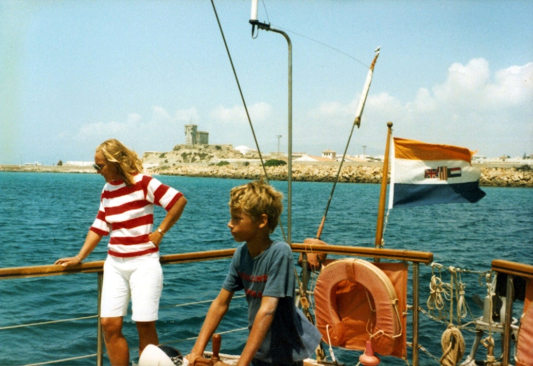 My mother and me on the deck with a Spanish coastal fortress behind.