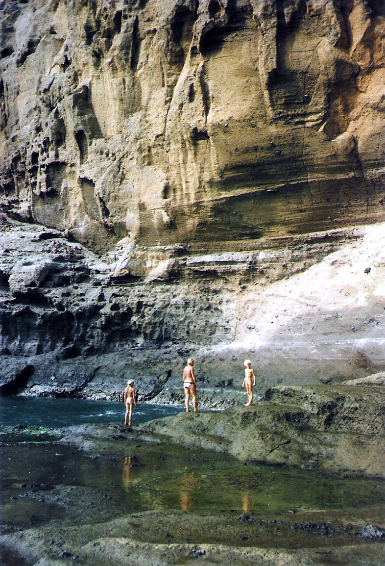 Children at the foot of volcanic cliffs on Ilha do Sal.